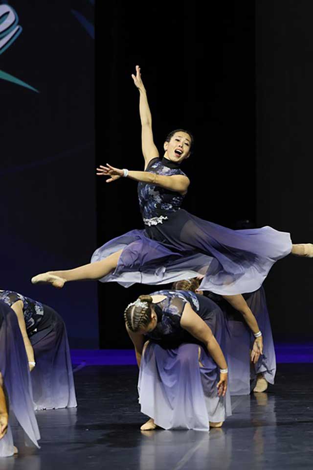 Solo dancer in high leap with flowing costume